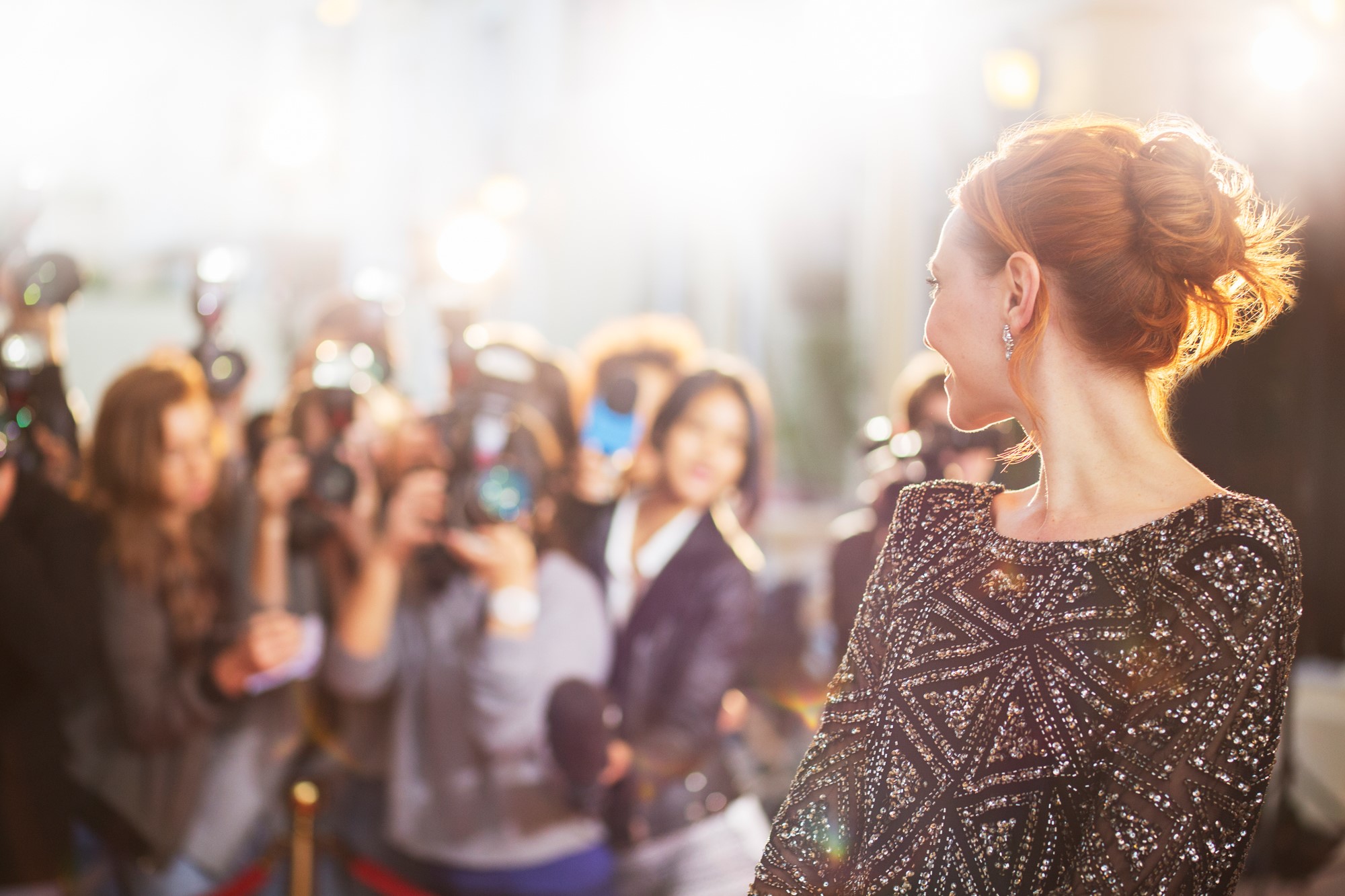 Celebrity posing for paparazzi and press at event